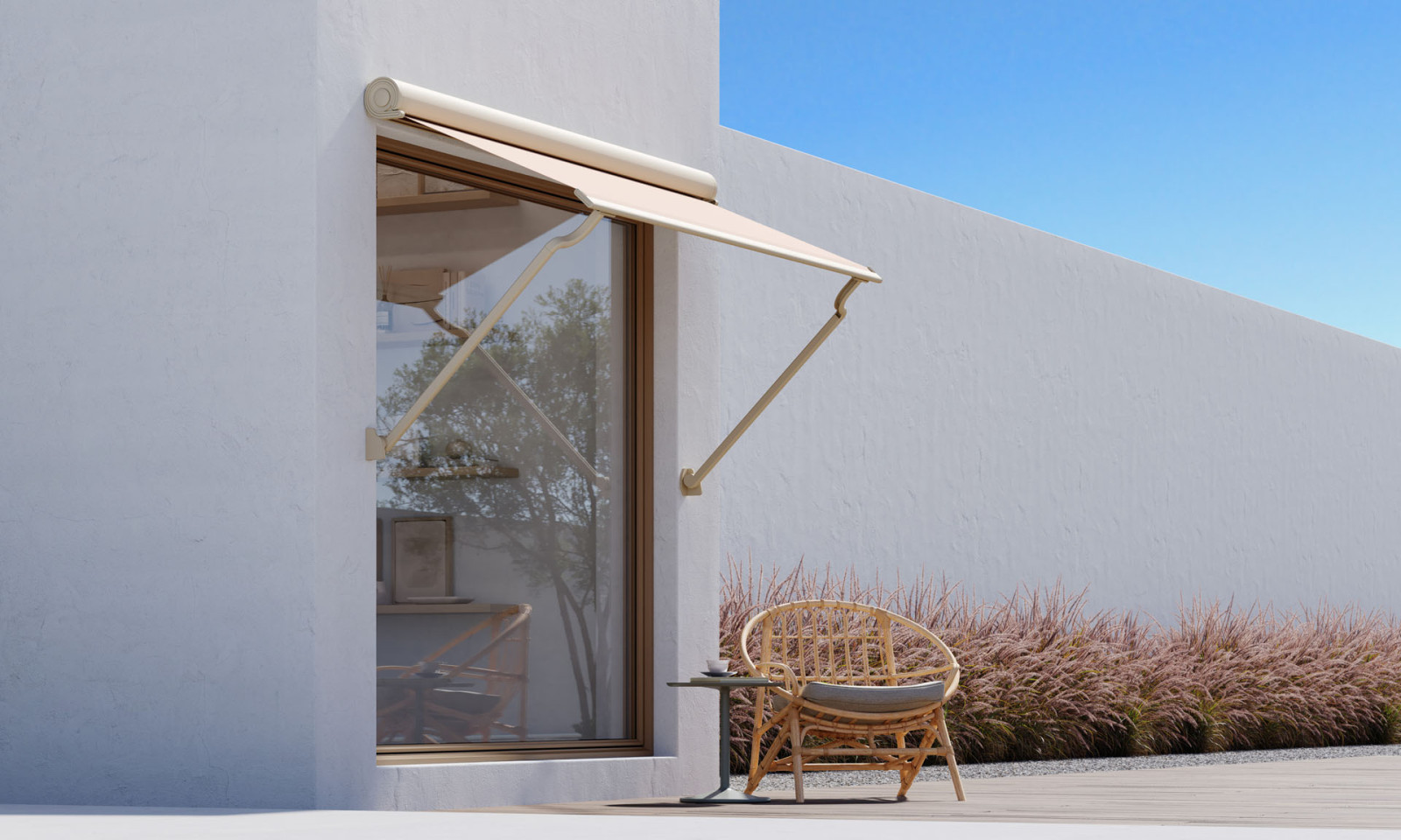 White house with wooden deck, modern lookin awning and and patio, surrounded by greenery.