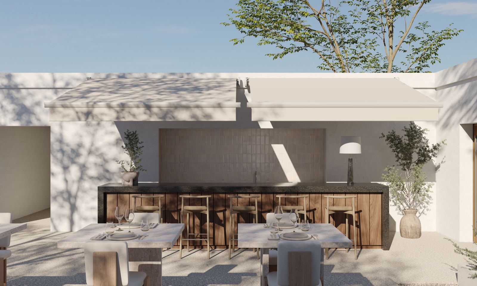 An outdoor patio with a nice-looking bar consists of a retractable awning and furniture overlooking majestic mountains.
