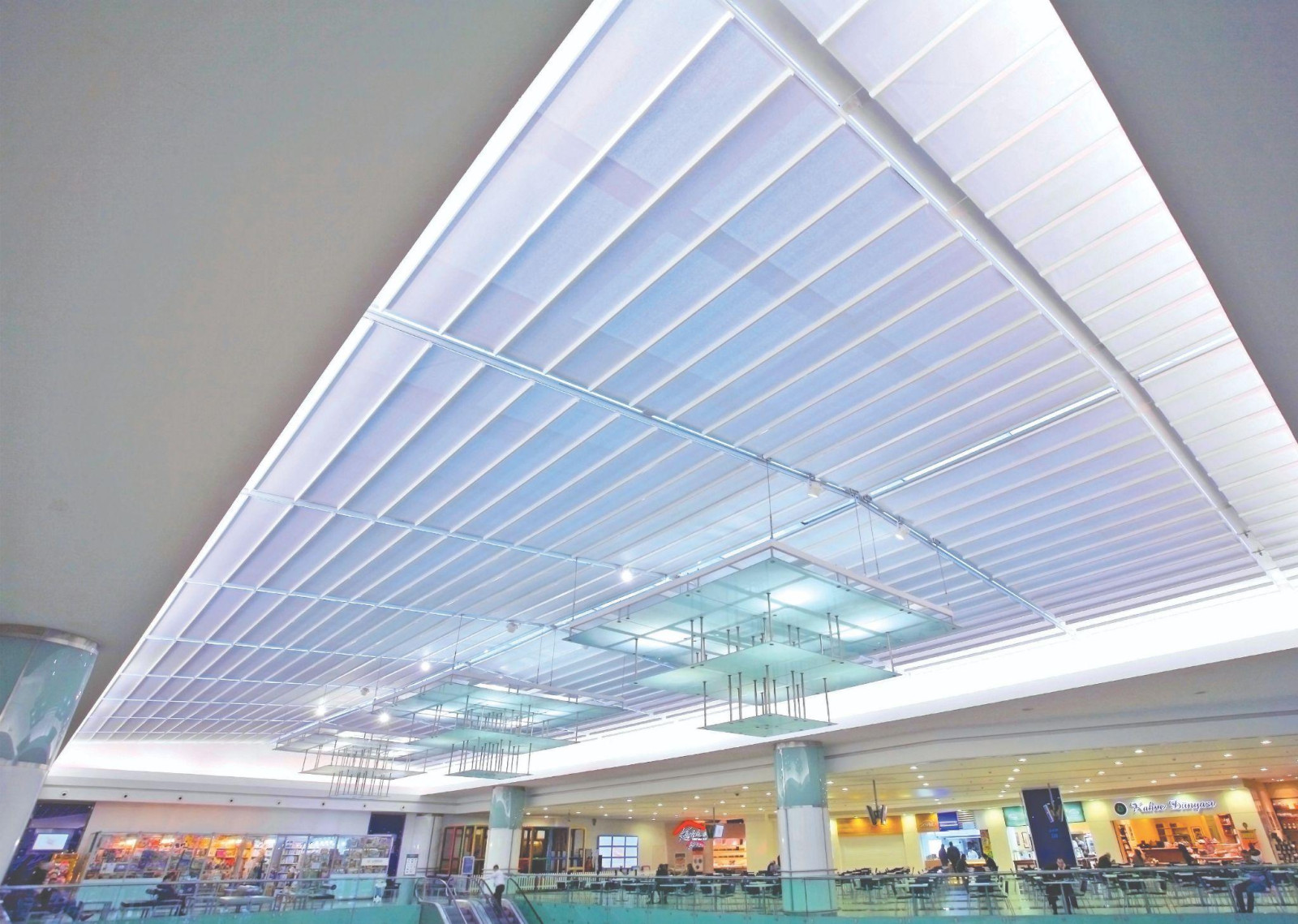 A large shopping mall offers modern aesthetics and technology with its illuminated ceiling.