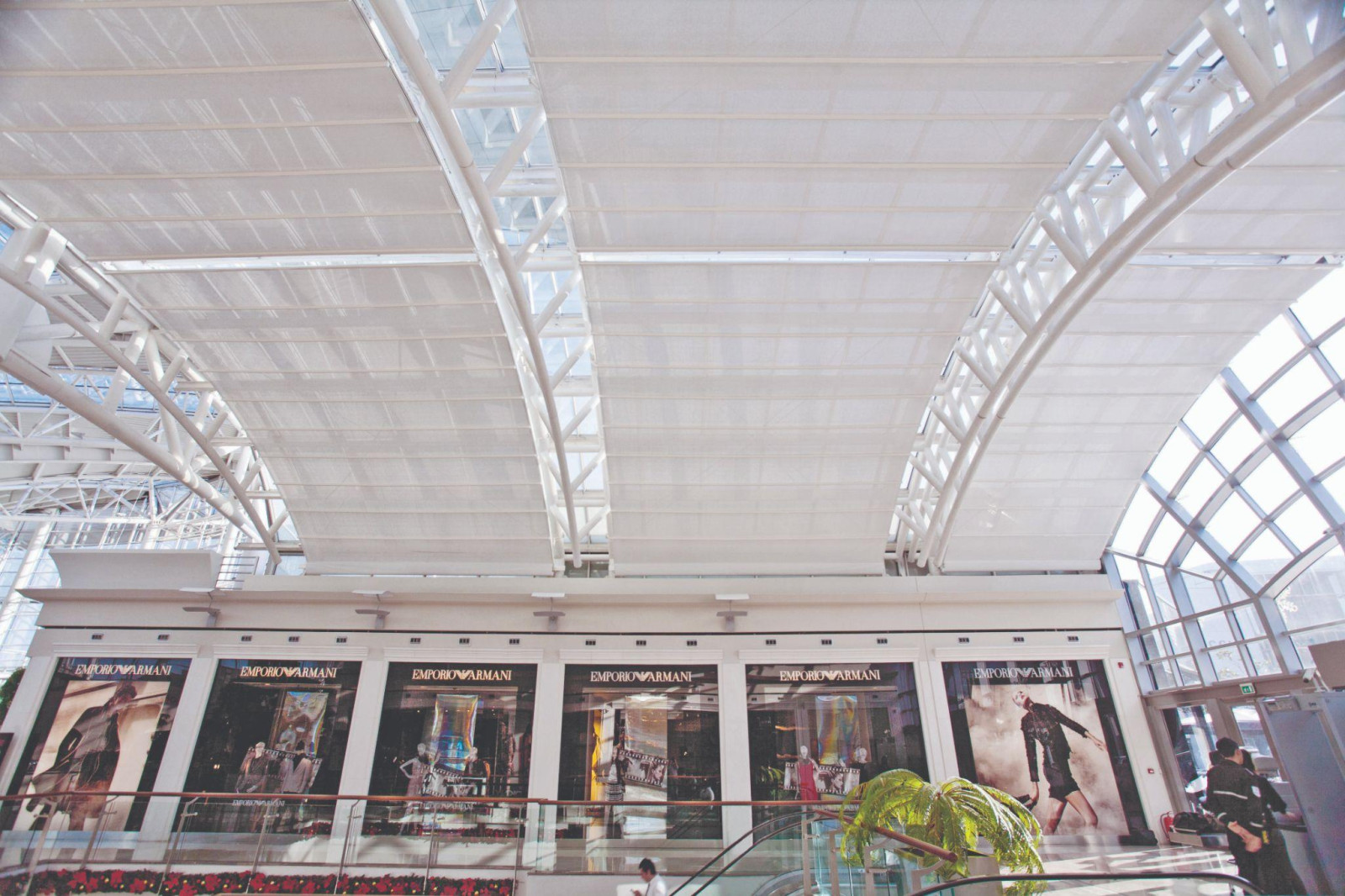 A large building with a clock in the middle attracts attention with shading solutions that enhance customer experience.