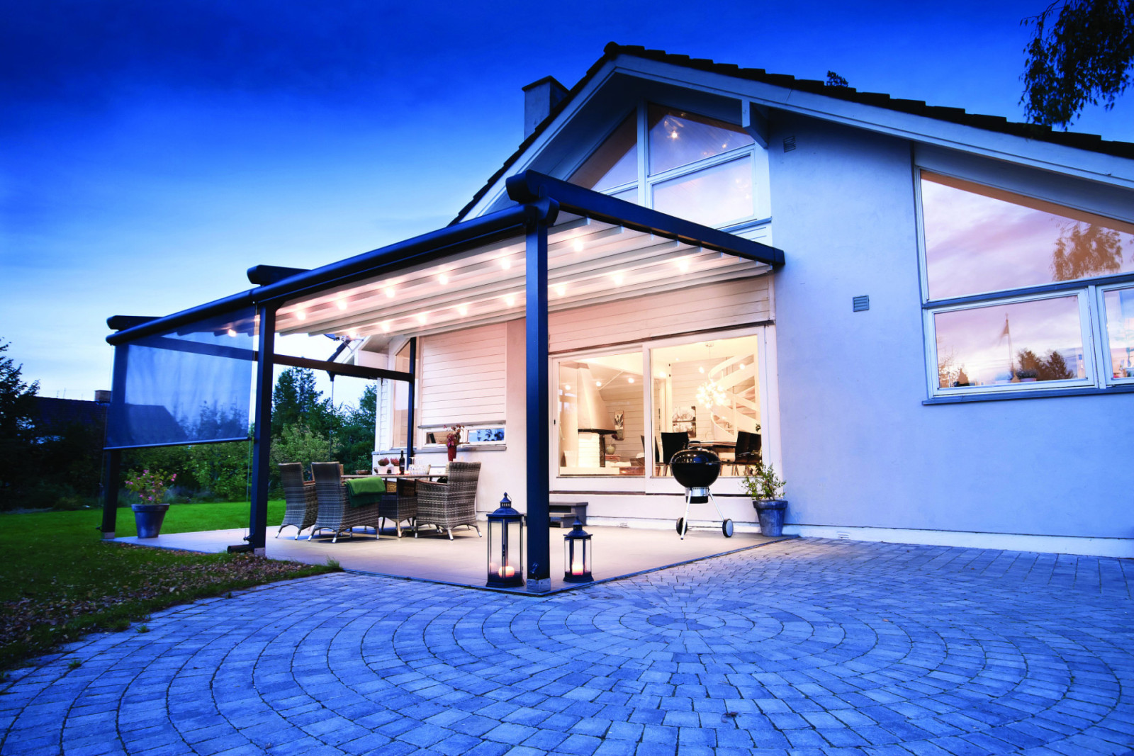 A stylish patio with a covered area and table, equipped with bioclimatic systems and ambient LED lighting.