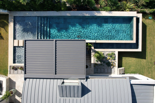 Havuz kenarında konumlandırılmış modern alüminyum pergola sistemi ile estetik ve fonksiyonel dış mekân tasarımı