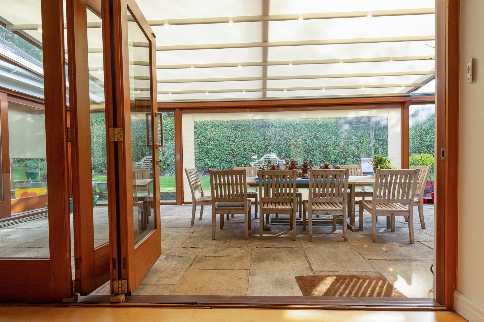 Warm and bright dining area beneath a pergola with wooden details