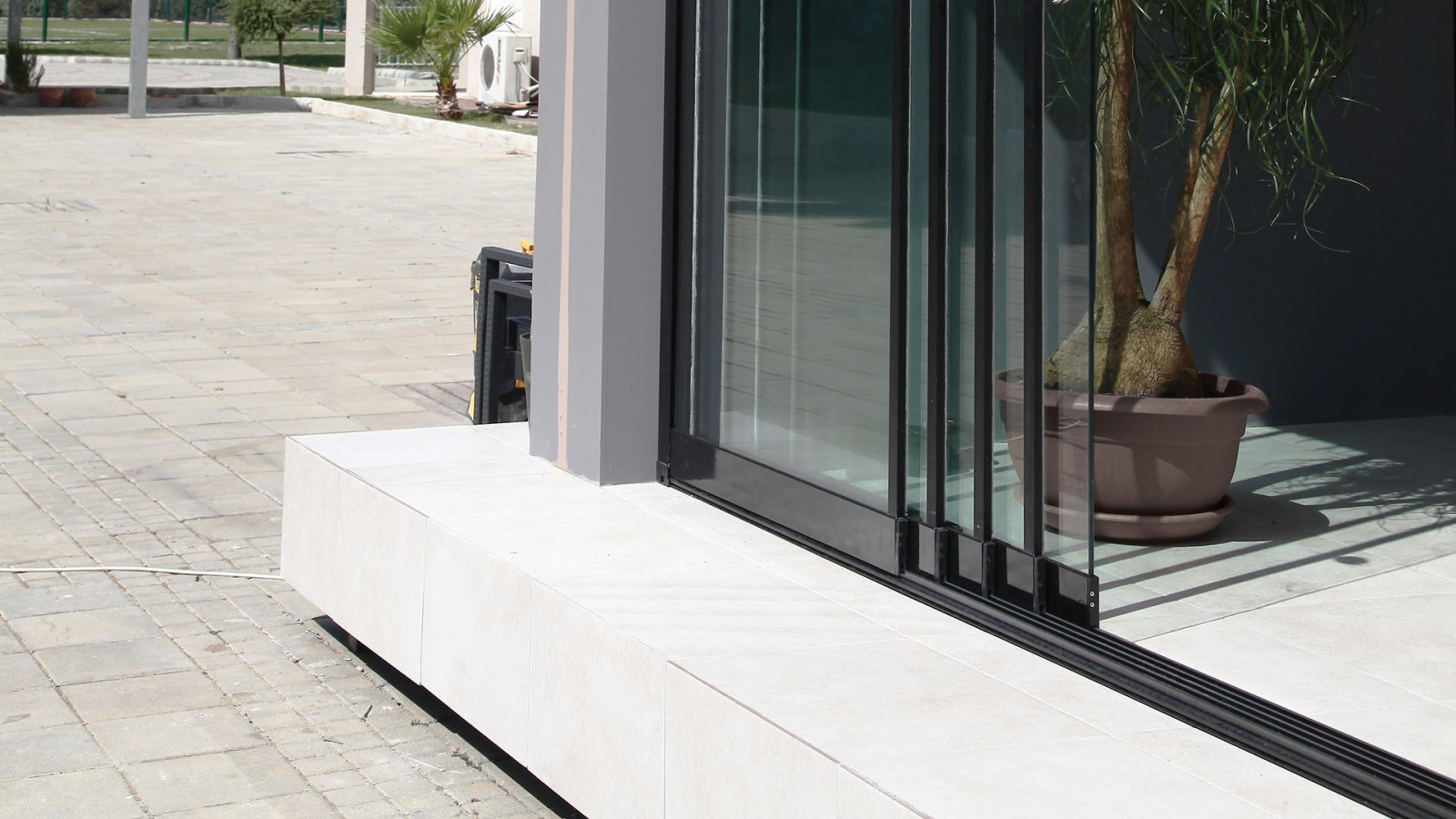 Black framed sliding glass system and floor track for a balcony enclosure