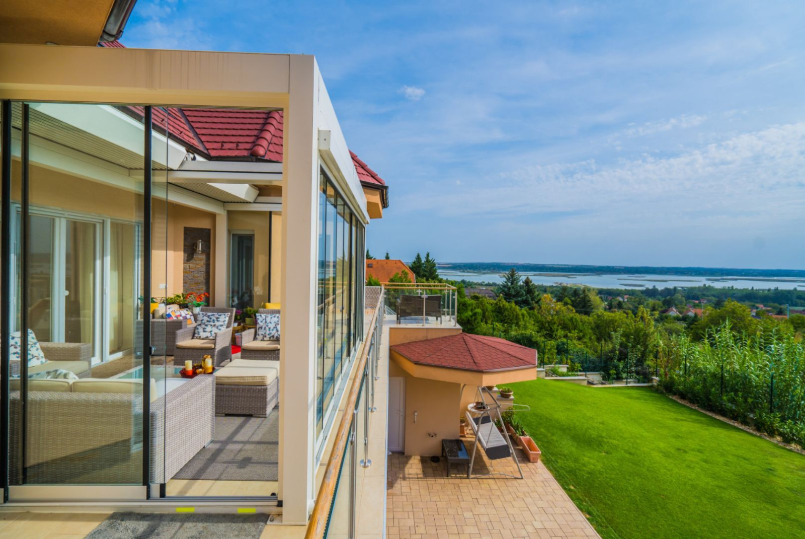 White pergola and glass enclosure coordinated with the home’s exterior